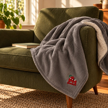 Heather Grey sleepy Pit throw draped over a green corduroy reading chair