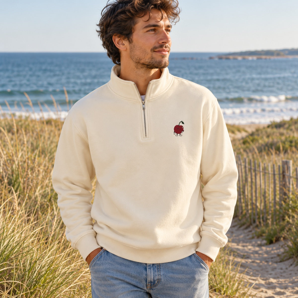Sandshell quarter-zip with little Pit chest embroidery on a coastal walk