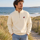 Sandshell quarter-zip with little Pit chest embroidery on a coastal walk