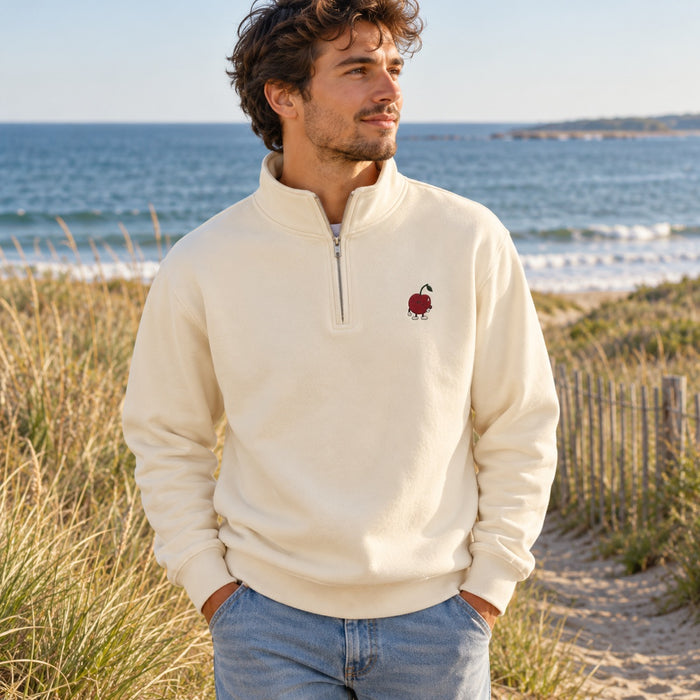 Sandshell quarter-zip with little Pit chest embroidery on a coastal walk