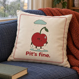 Pit’s Fine cushion on an indigo sofa beside a rainy window